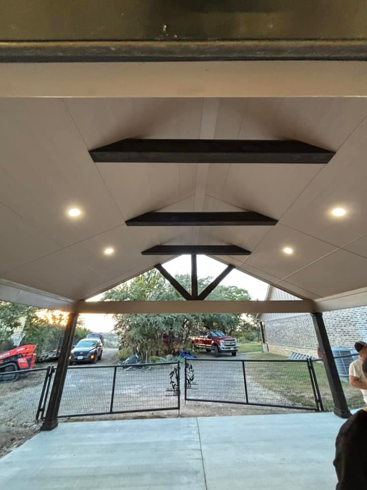 Custom recessed lighting installation in covered patio with exposed beams in Granbury Texas residential property